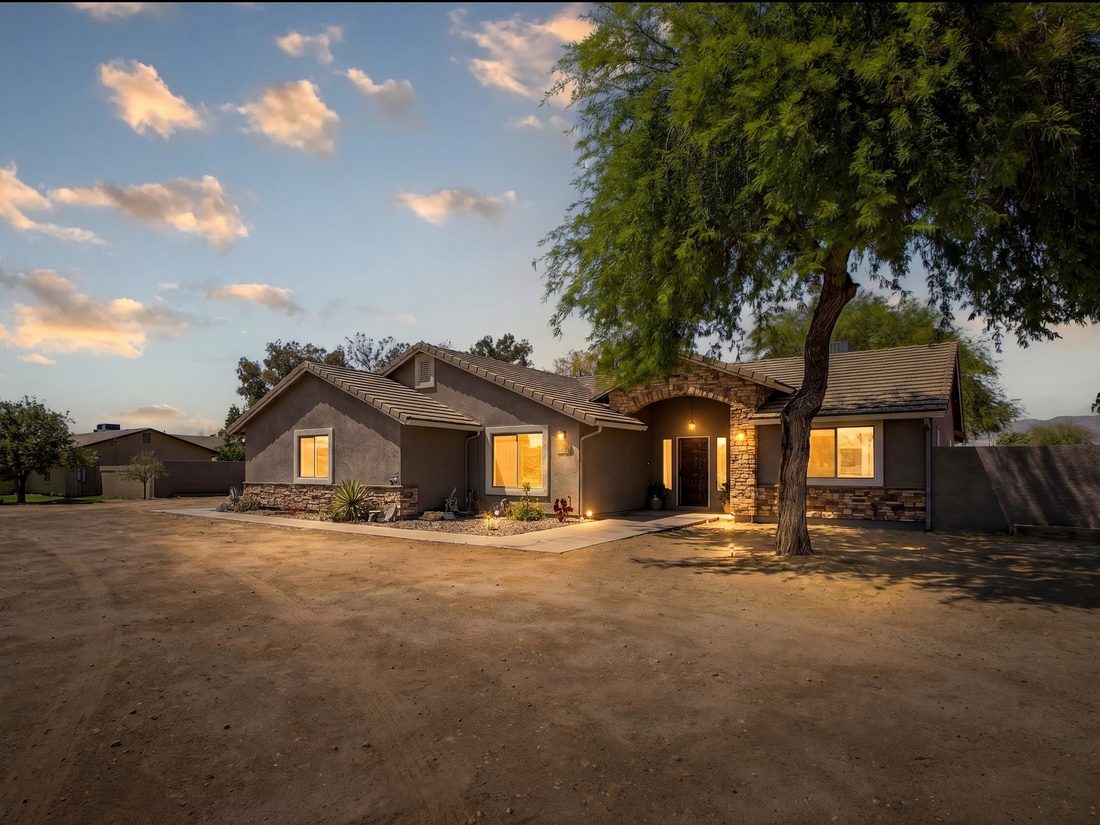 A home at dusk with the lights on, one of the properties Honeybird Homes purchased.